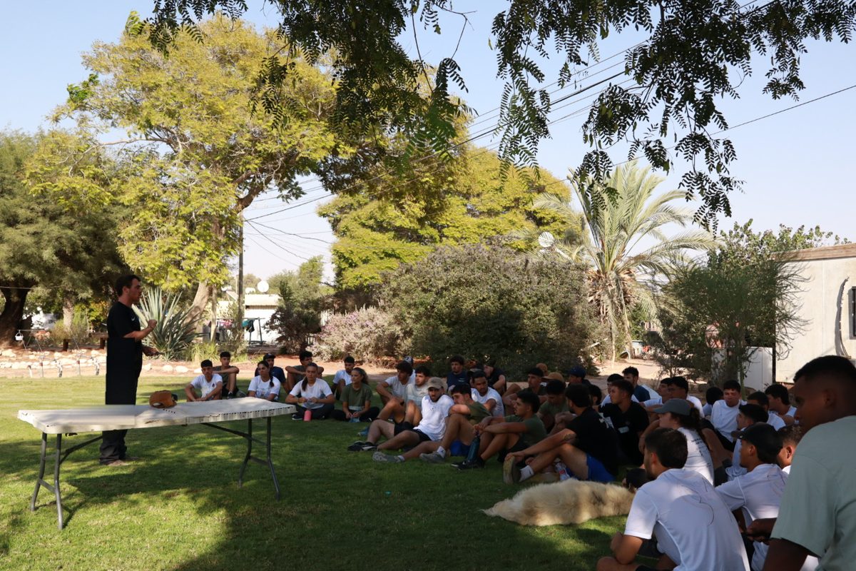 שקד מרצה בפני קבוצה גדולה של צעירים על הדשא